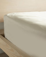 Dune-toned cotton percale fitted sheet on a mattress