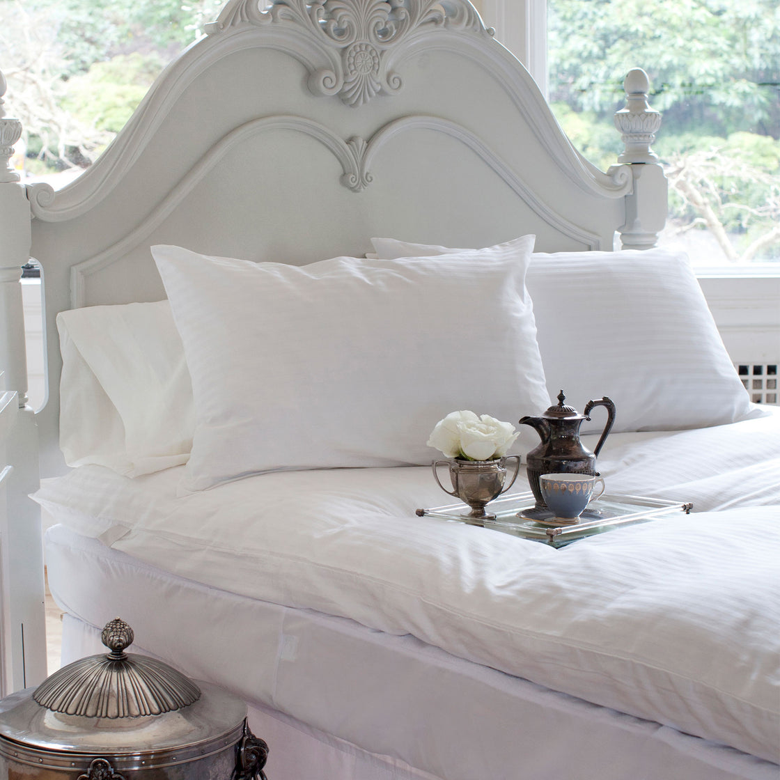 St. Geneve pillow protectors on a bed with crisp white striped pillows