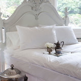 St. Geneve pillow protectors on a bed with crisp white striped pillows